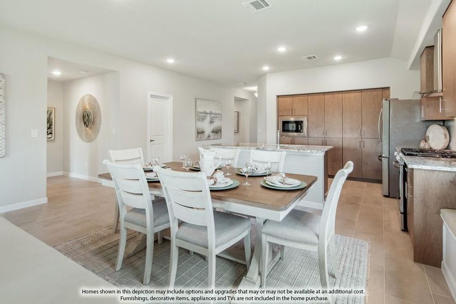 Dining area with six-seat white table open to kitchen with dark wood cabinets and stainless steel appliances