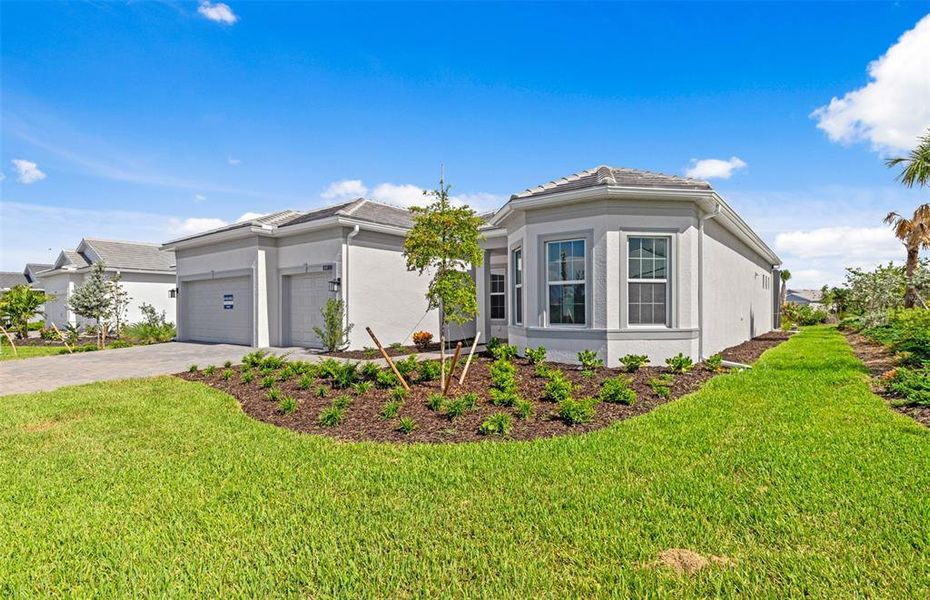 Front exterior of a new home in BeachWalk by Manasota Key, Englewood, FL, highlighting curb appeal (Image 2). Front exterior of a new home in BeachWalk by Manasota Key, Englewood, FL, highlighting curb appeal (Image 2).
