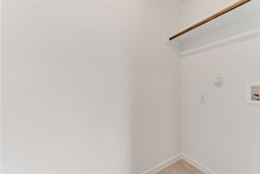 Laundry room with washer hookup, laundry area, light wood-style flooring, and baseboards