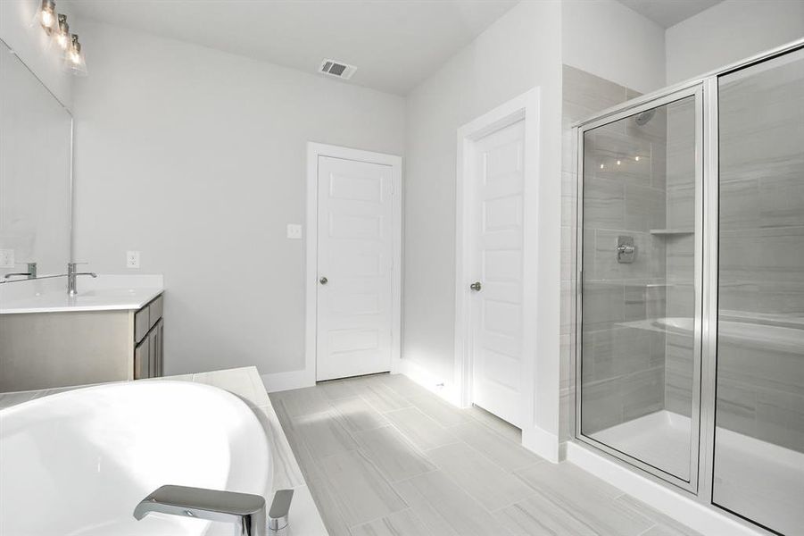 Experience a spa-like escape right in the heart of your primary bathroom. Theexpansive walk-in shower, surrounded by tile, and the distinctive garden tubwith unique accents elevate your daily routine.