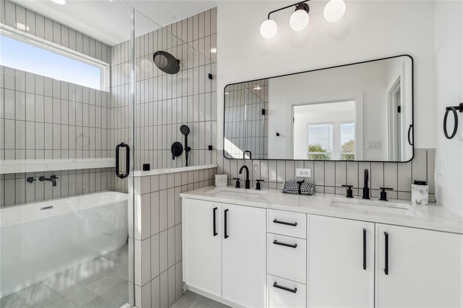 The primary ensuite is truly stunning with vertical tiles, dual sinks and a new design with a shampoo counter with a walk-in shower and stand alone tub enclosed.