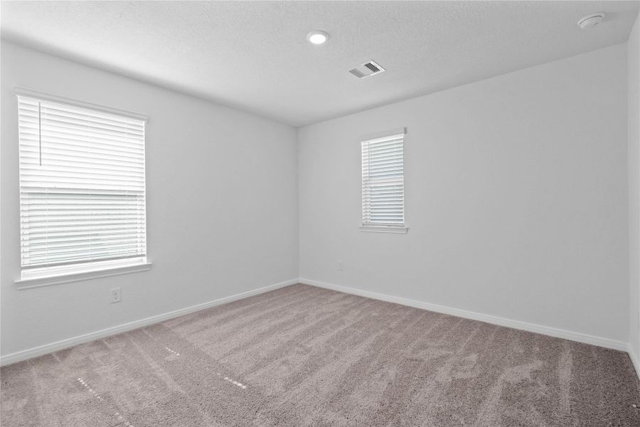 This secondary bedroom offers comfort and style with plush carpeting, neutral paint tones, recessed lighting, large windows with blinds, and a generously sized closet. This secondary bedroom offers comfort and style with plush carpeting, neutral paint tones, recessed lighting, large windows with blinds, and a generously sized closet.