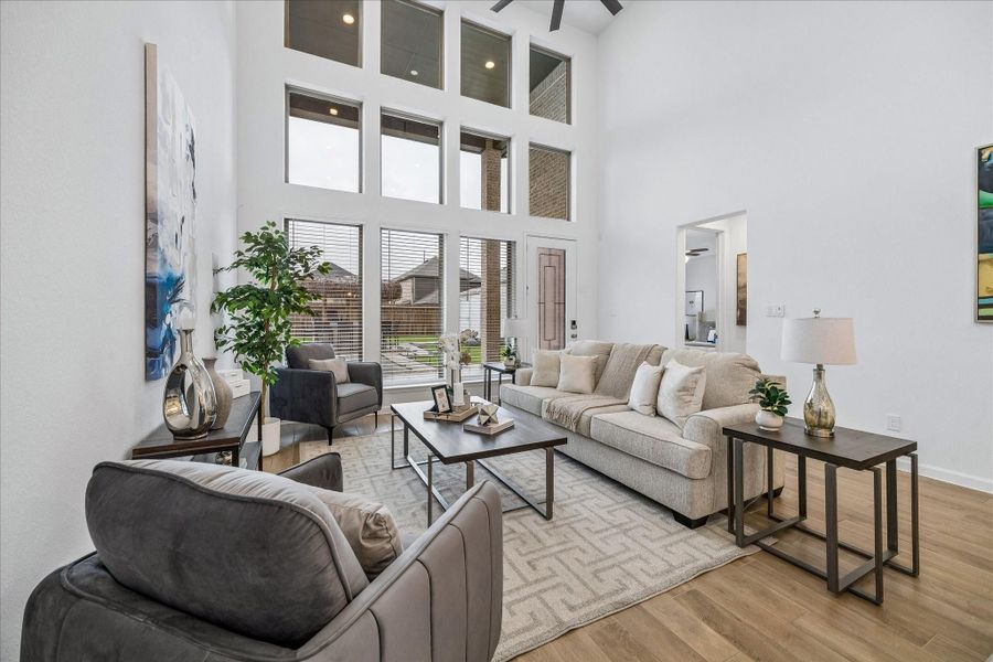 Designed for everyday comfort and easy gathering, the open family room has an open airy vibe with tall ceilings, abundant natural light, and a seamless connection to the dining area and kitchen.