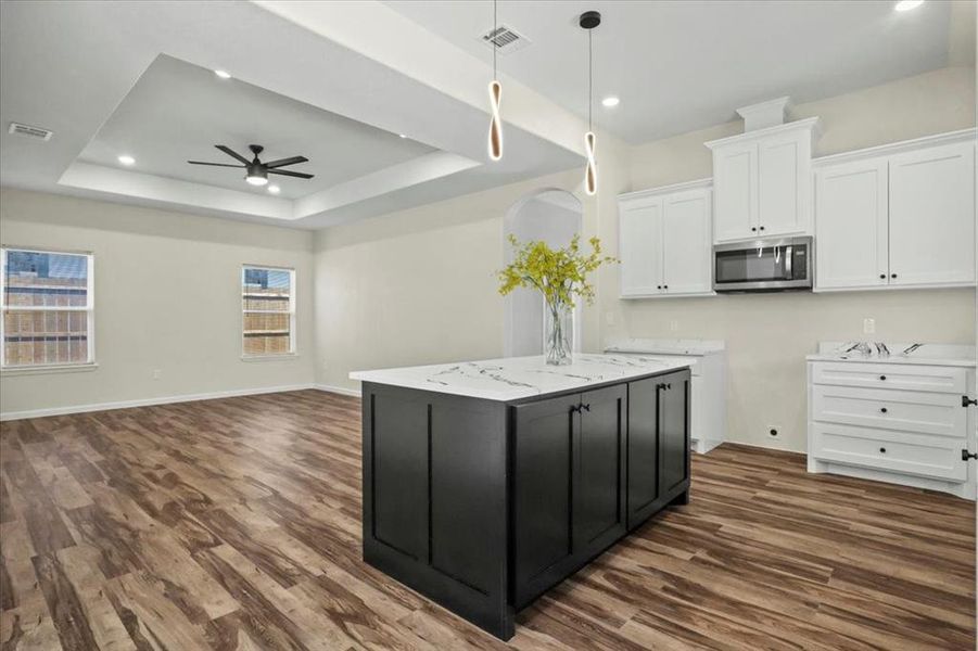Kitchen with white cabinets, open floor plan, dark cabinetry, dark wood-style floors, and recessed lighting Kitchen with white cabinets, open floor plan, dark cabinetry, dark wood-style floors, and recessed lighting