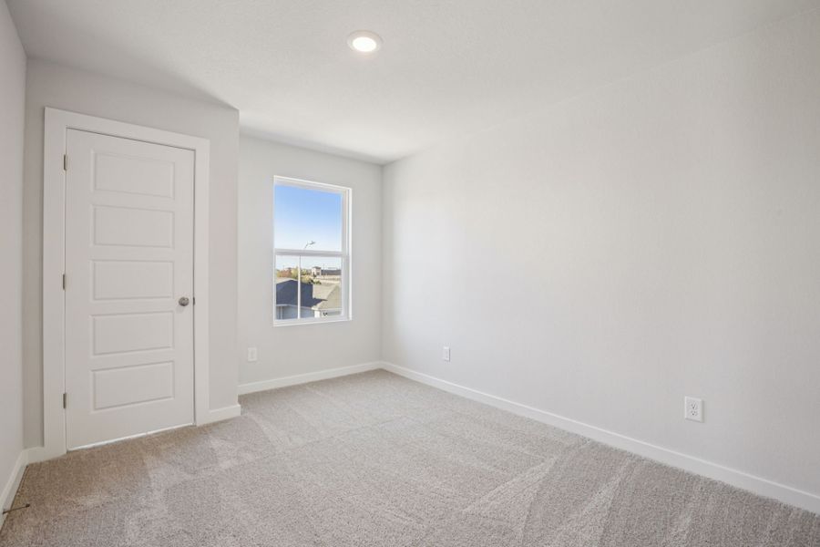 A room with a window and a carpet.