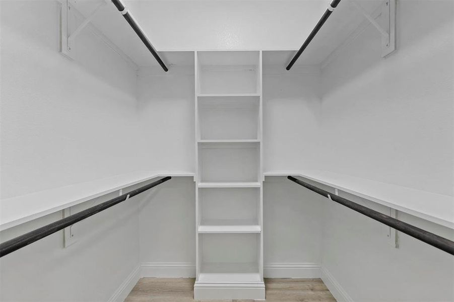 Walk in closet with light wood-type flooring