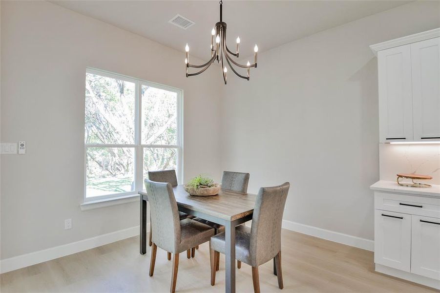 Dining room featuring light wood-style floors and a chandelier Dining room featuring light wood-style floors and a chandelier
