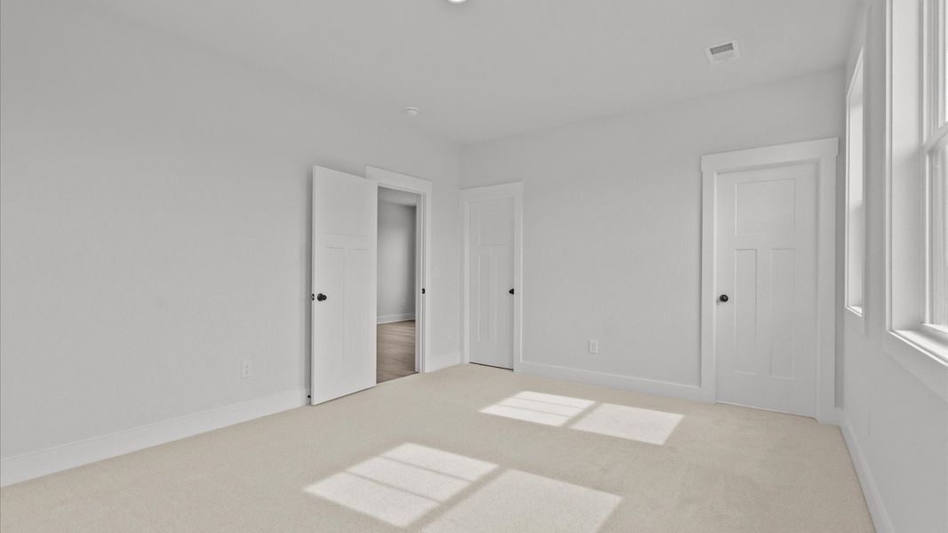 Accomplished design shines in this carpeted bedroom with a functional walk-in closet