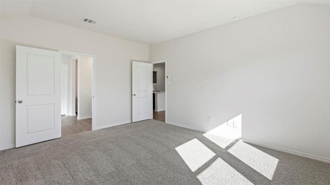 Unfurnished bedroom with vaulted ceiling and carpet Unfurnished bedroom with vaulted ceiling and carpet