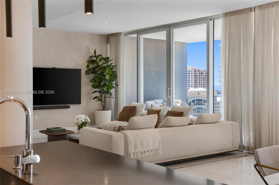Floor-to-ceiling glass sliding doors, recessed lighting, matte-finish countertop with gooseneck faucet, and expansive glass pane enclosures