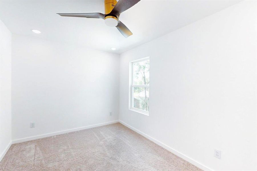 Spare room with ceiling fan and light colored carpet