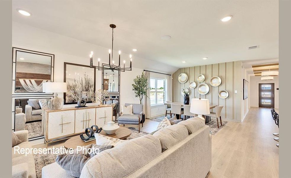 Spacious interior featuring light wood-finish flooring, recessed lighting, and a modern chandelier