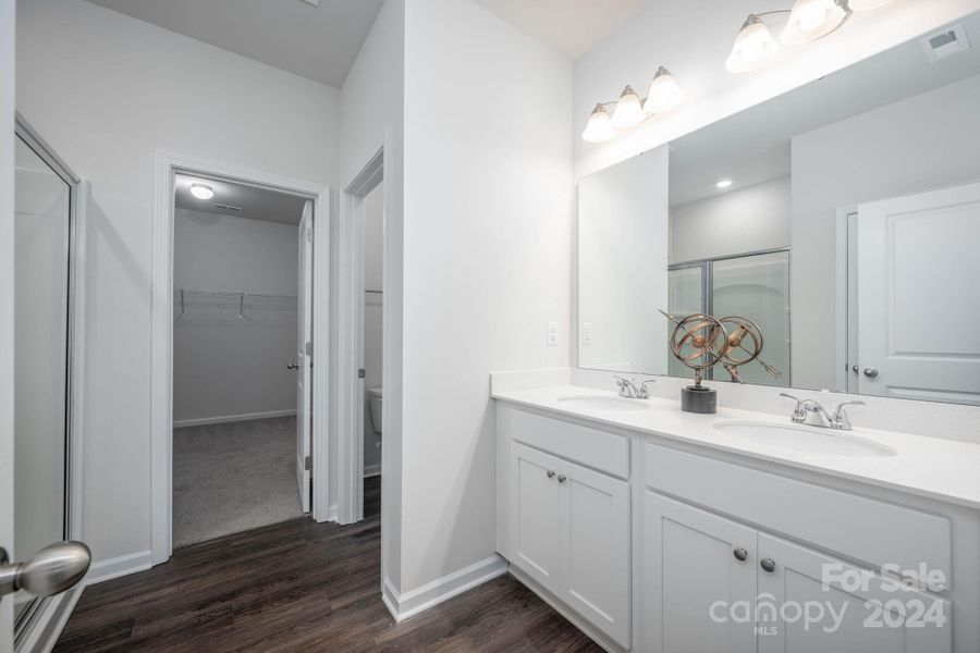 Primary full bath with dual sinks and walk-in closet