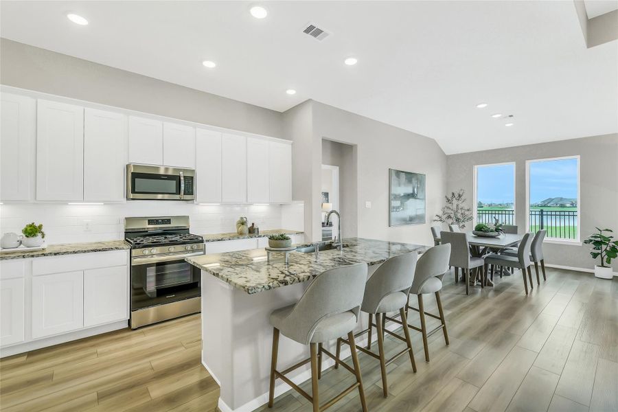 Expansive granite island serves as the heart of the home, adjacent to the bright breakfast dining area.