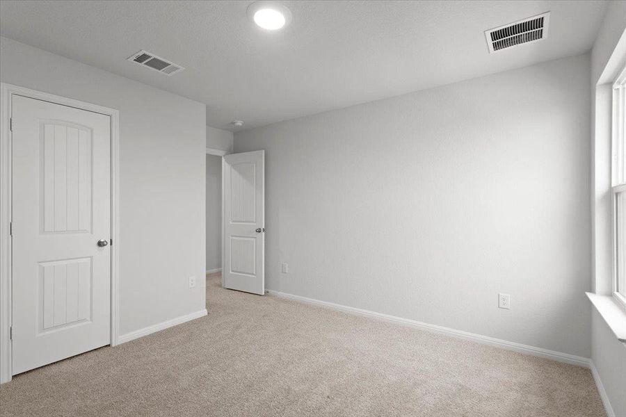 Neutral-toned carpeting spans the room, complemented by light gray walls and white trim