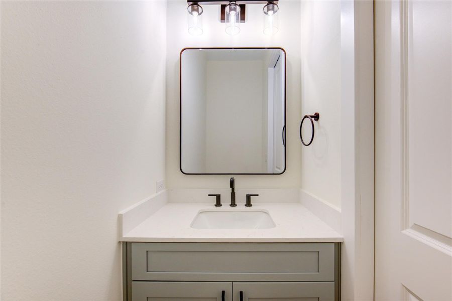 Elegant half bathroom featuring modern fixtures, sleek vanity, and a chic mirror, perfect for guests. Elegant half bathroom featuring modern fixtures, sleek vanity, and a chic mirror, perfect for guests.