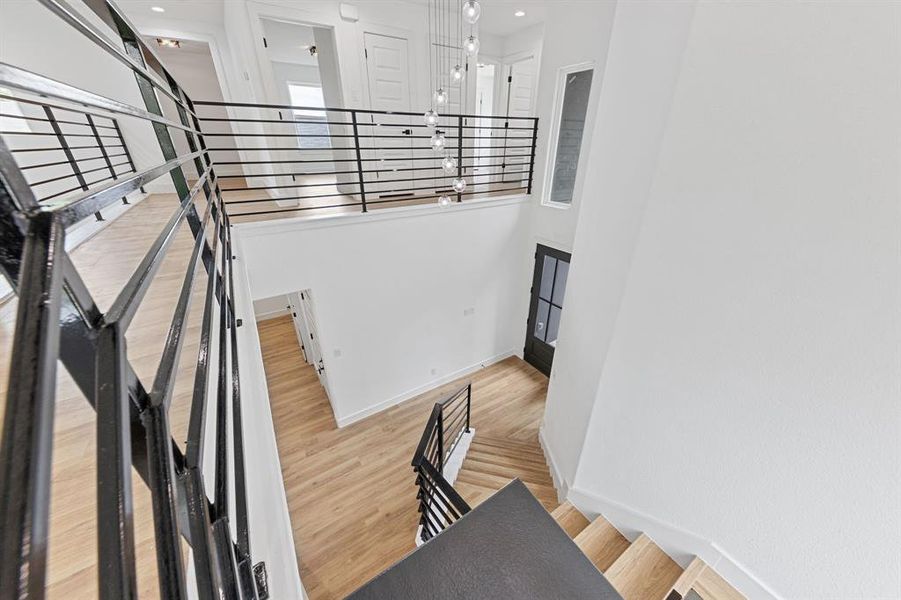 The property features a staircase with light-colored wooden steps and contemporary black metal railings, leading to a landing with a similar railing design The property features a staircase with light-colored wooden steps and contemporary black metal railings, leading to a landing with a similar railing design