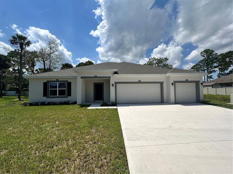 Front exterior of a new home in Palm Coast: Value Collection, Palm Coast, FL, highlighting curb appeal (Image 1).