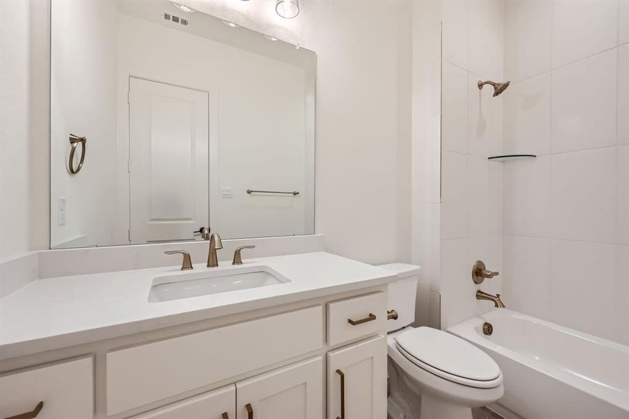 Full bathroom featuring vanity, toilet, and tiled shower / bath