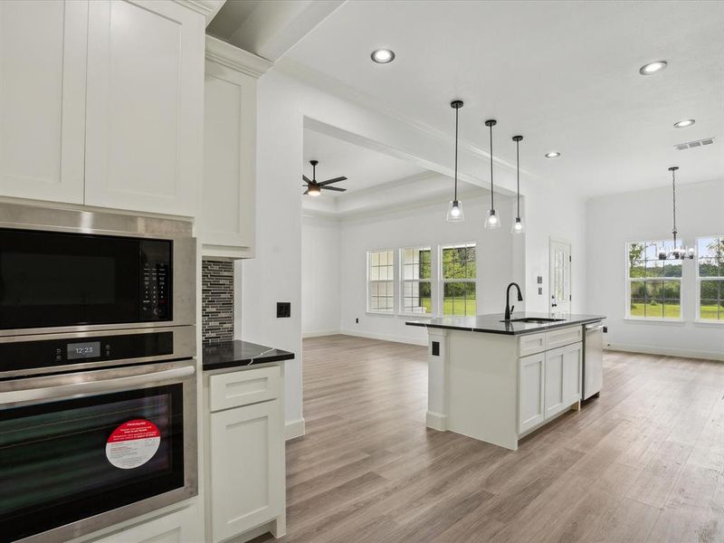 Kitchen featuring light wood-type flooring, appliances with stainless steel finishes, a healthy amount of sunlight, and sink