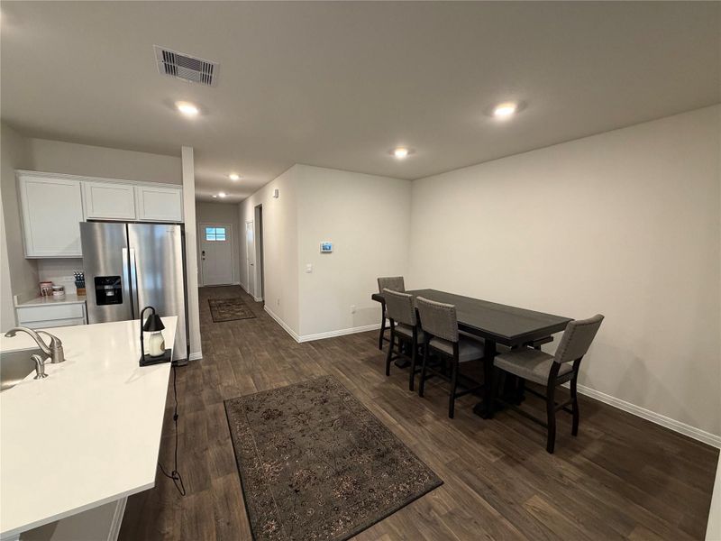 Dining space with dark wood-style floors and recessed lighting