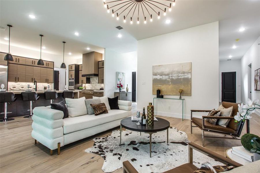 Living room with light wood-type flooring and an inviting chandelier