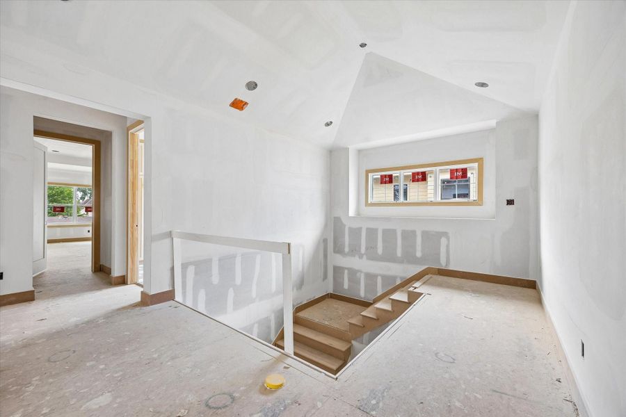 Light filled upper landing with vaulted ceiling detail and recessed lighting, creating an open transition to the game room and secondary bedrooms. Well placed window brings in natural light while maintaining privacy. Light filled upper landing with vaulted ceiling detail and recessed lighting, creating an open transition to the game room and secondary bedrooms. Well placed window brings in natural light while maintaining privacy.