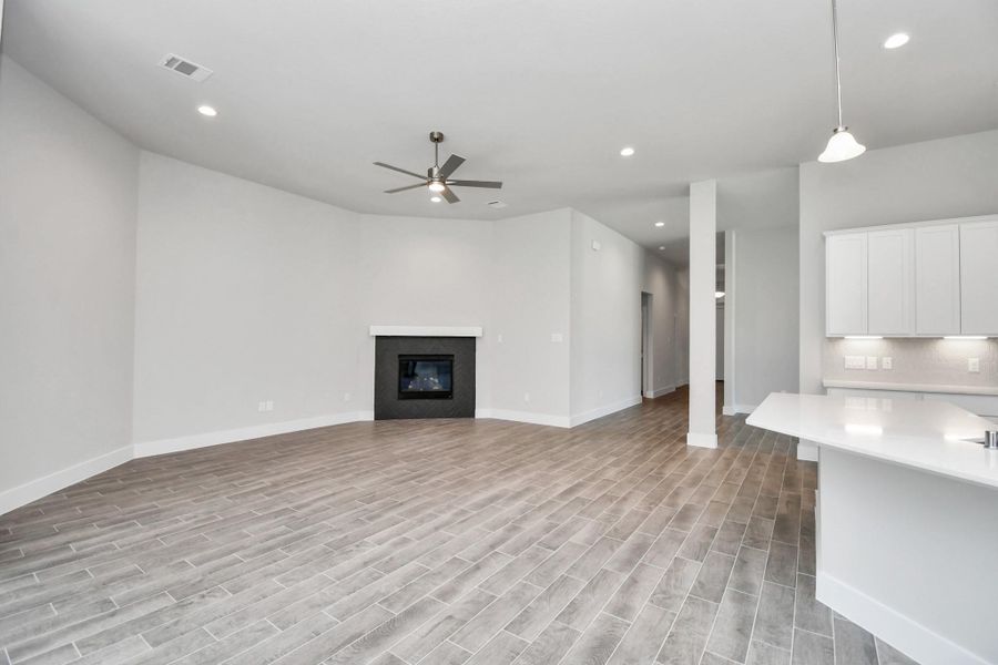 Welcome family and guests to your charming living room! With its high ceilings, recessed lighting, ceiling fan, custom paint, beautiful flooring, and large windows that let in abundant natural light, this room is perfect for gatherings. Sample photo of completed home with similar floor plan. Actual colors and selections may vary. Welcome family and guests to your charming living room! With its high ceilings, recessed lighting, ceiling fan, custom paint, beautiful flooring, and large windows that let in abundant natural light, this room is perfect for gatherings. Sample photo of completed home with similar floor plan. Actual colors and selections may vary.