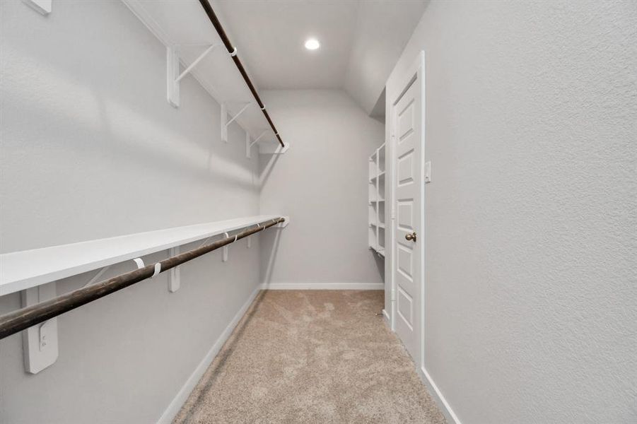 Walk-in closet that epitomizes luxury and practicality. This generously sized space features built-in shelving, offering abundant room for impeccable organization. High ceilings and recessed lighting create a bright and welcoming ambiance.