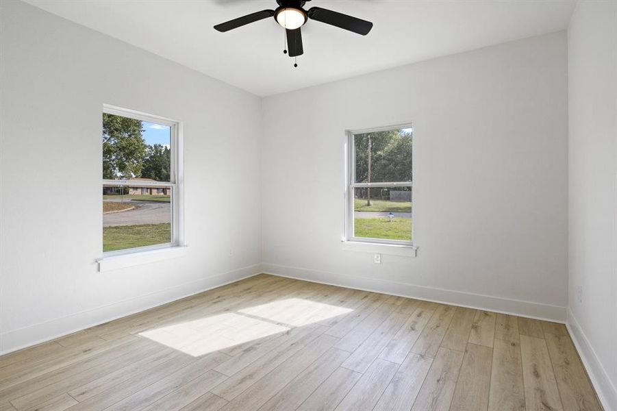 Unfurnished room featuring light wood-style floors and ceiling fan