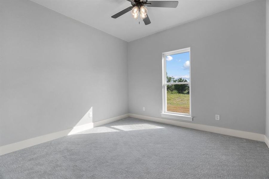 Empty room with carpet and a ceiling fan