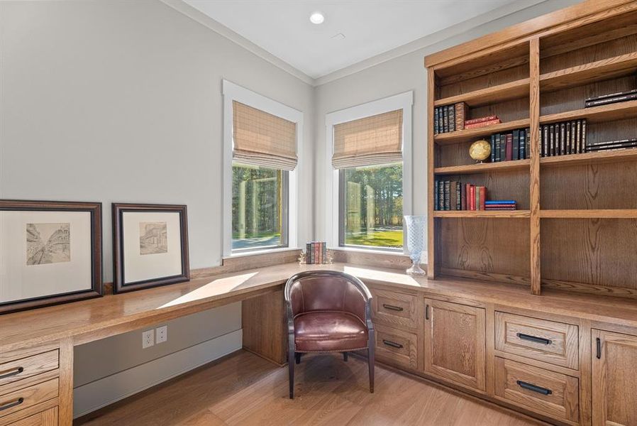 Sitting room with built in desk, light wood-style floors, ornamental molding, and recessed lighting