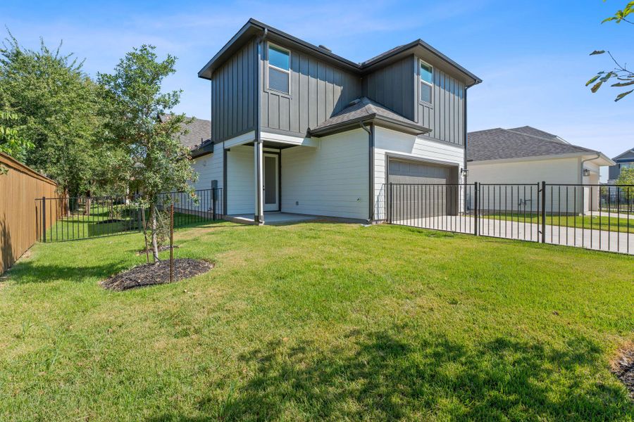 Back of house with board and batten siding, a patio, an attached garage, and concrete driveway