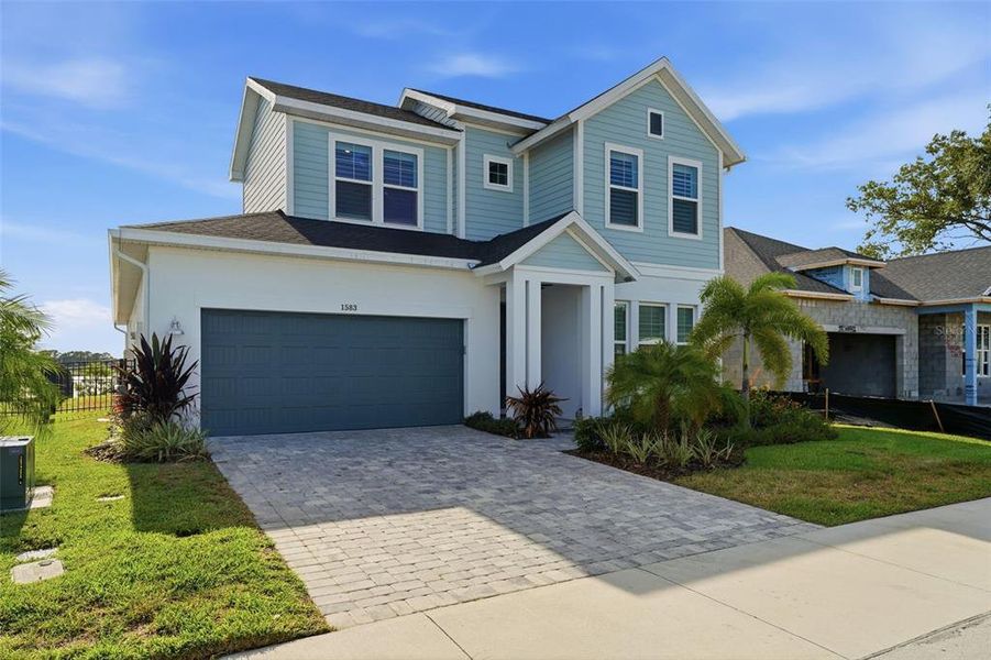 Front exterior of a new home in Emerald Landing at Waterside at Lakewood Ranch – Lake Series, Sarasota, FL, highlighting curb appeal (Image 24). Front exterior of a new home in Emerald Landing at Waterside at Lakewood Ranch – Lake Series, Sarasota, FL, highlighting curb appeal (Image 24).