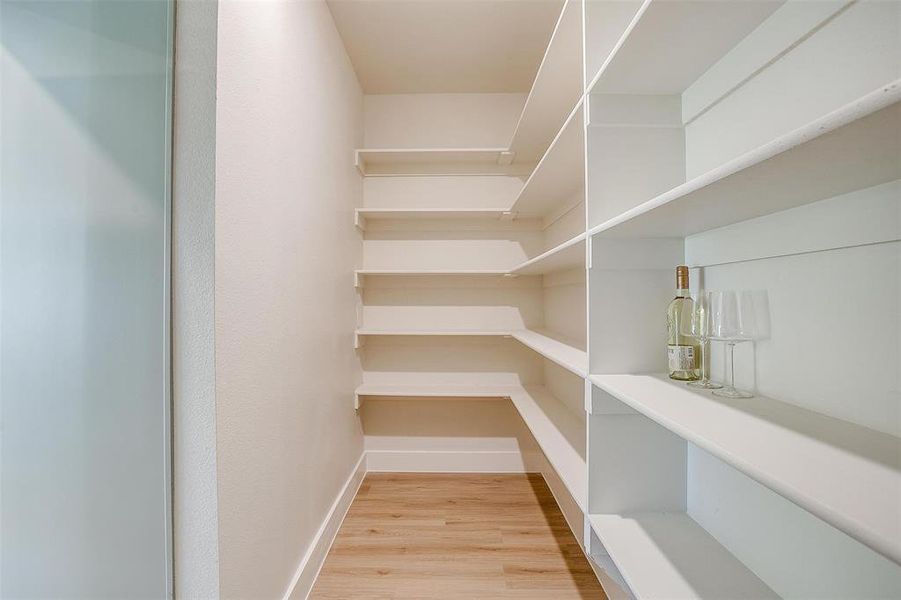 The hidden walk-in pantry features ample storage.