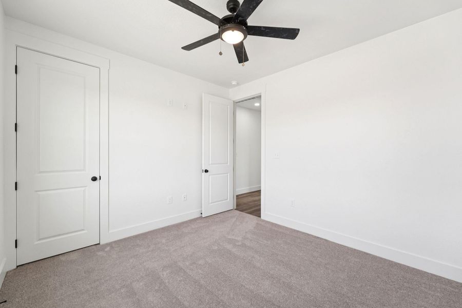 Unfurnished bedroom featuring carpet and ceiling fan