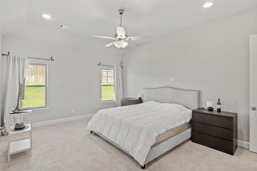 Bedroom with ceiling fan and light colored carpet