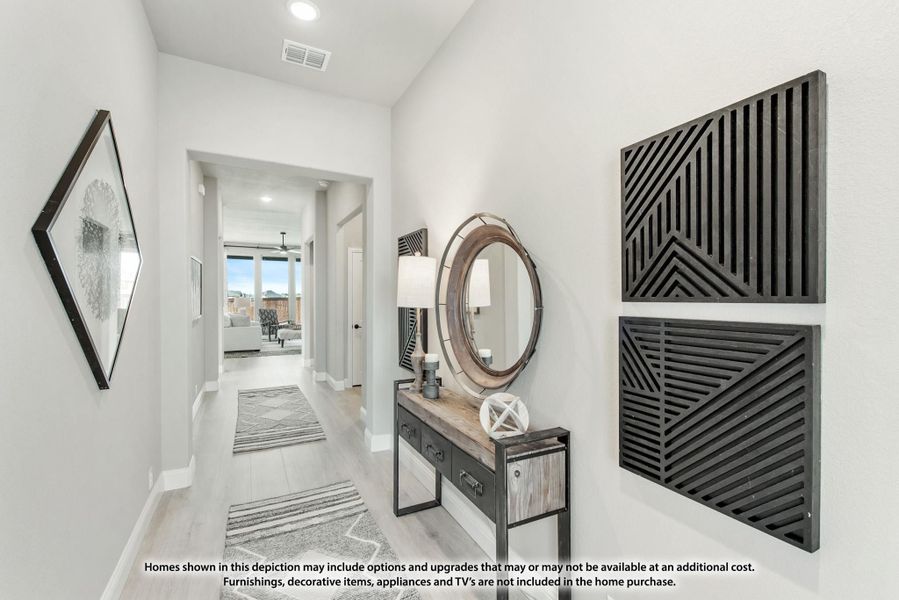 Hallway with light wood floors, console table, round mirror, and decorative wall art leading to living room Hallway with light wood floors, console table, round mirror, and decorative wall art leading to living room