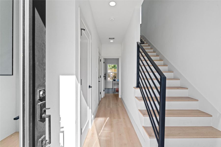 A bright entry corridor framed by nine-foot ceilings & contemporary iron rails, opening to a guest bedroom with its own ensuite. A bright entry corridor framed by nine-foot ceilings & contemporary iron rails, opening to a guest bedroom with its own ensuite.