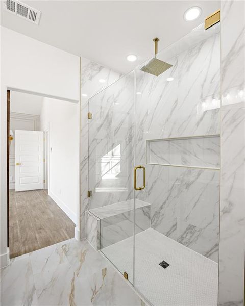Full bath with a marble finish shower, light marble finish flooring, and recessed lighting