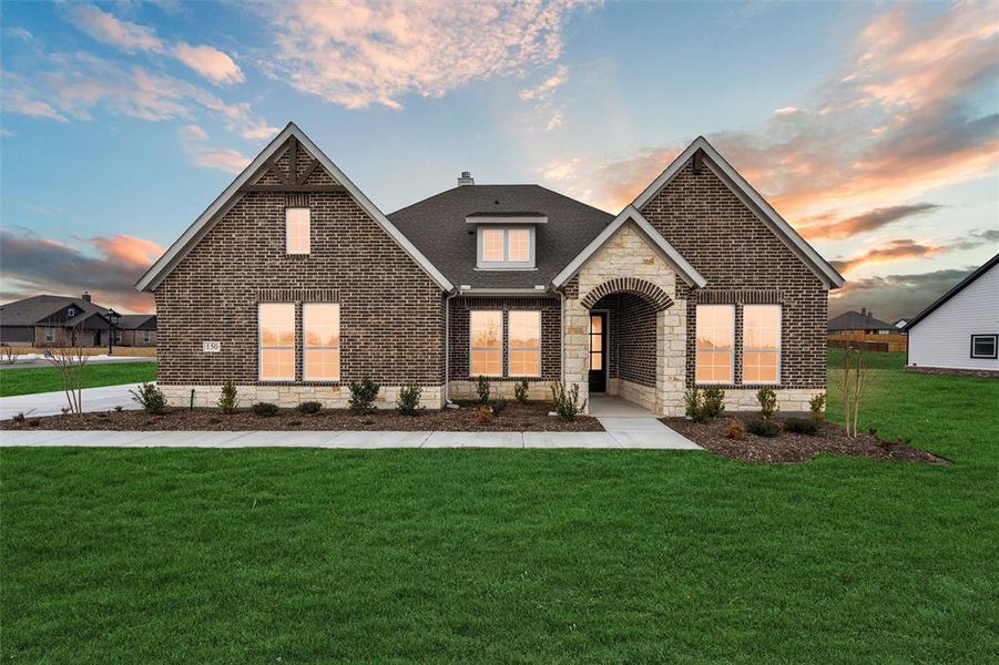 View of front of house with a yard, stone siding, brick siding, and roof with shingles View of front of house with a yard, stone siding, brick siding, and roof with shingles