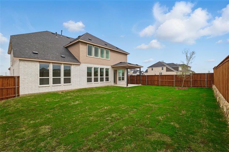 Back of house with a lawn, brick siding, a fenced backyard, and a patio area Back of house with a lawn, brick siding, a fenced backyard, and a patio area
