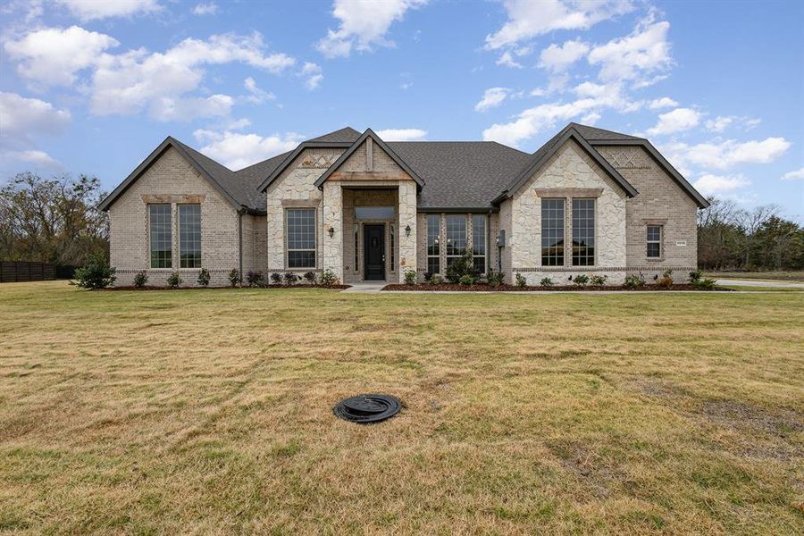 French country home featuring a front yard