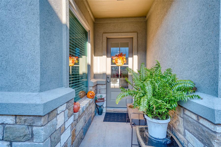 Doorway to property with stucco siding and a porch