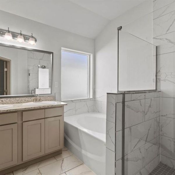 The primary bath feature dual sinks with large vanity, large soaking tub and glass framed standing shower. **This image is from another Saratoga Home with similar floor plan - Myrtle Floorplan.**