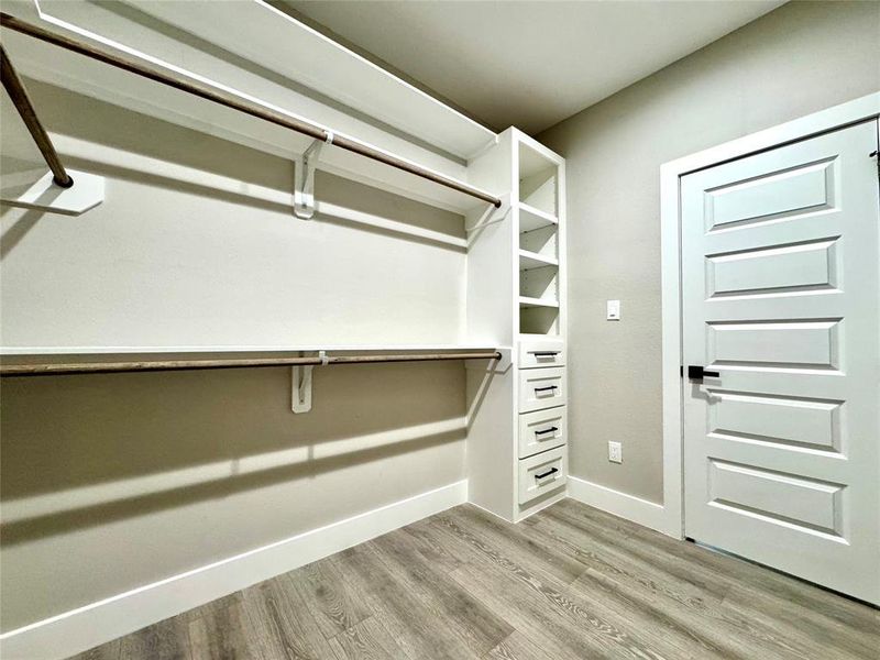 Primary bedroom closet with custom cabinetry.