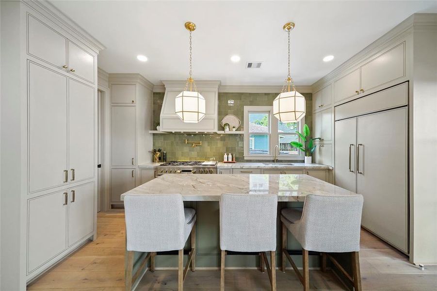 Stunning kitchen with art deco lighting. Plenty of storage all around.