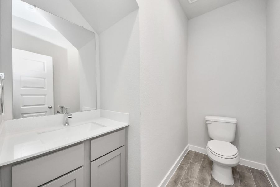 This half bathroom features a stylish pedestal sink, modern hardware, and bright recessed lighting, creating a sleek and inviting space. Sample photo of completed home with similar floor plan. Actual colors and selections may vary.