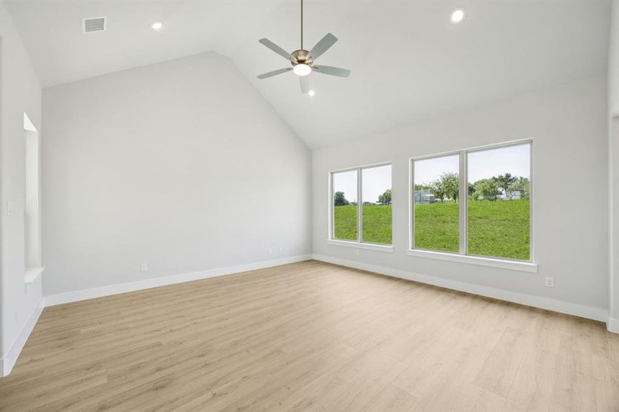 Empty room featuring light wood-type flooring, high vaulted ceiling, recessed lighting, and a ceiling fan