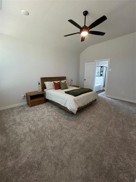 Bedroom with carpet, lofted ceiling, and a ceiling fan Bedroom with carpet, lofted ceiling, and a ceiling fan